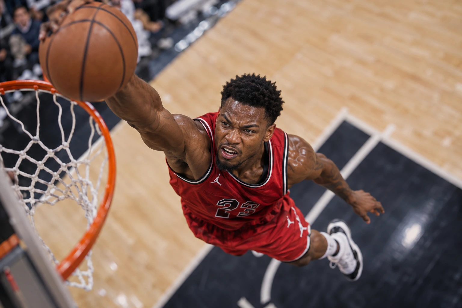 Basketball dunk from an elevated angled camera, focused on the player’s strained expression above a blurred court